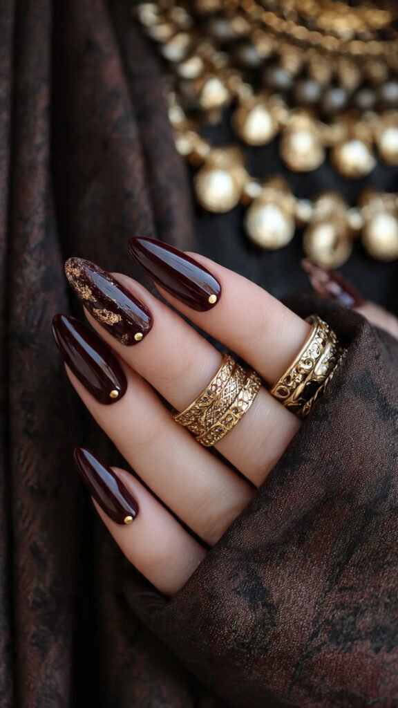 deep-burgundy-nails-with-gold-foil-accents-and-tin